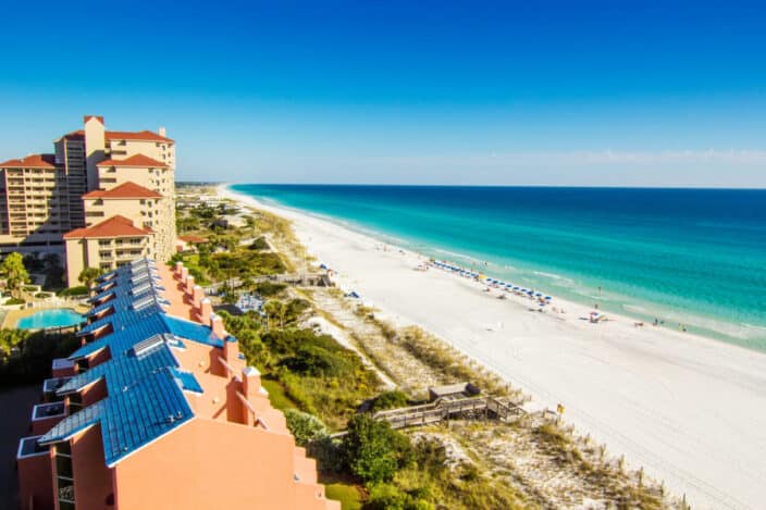 white beach, turquoise water of the Gulf, colorful hotels on the edge of the beach