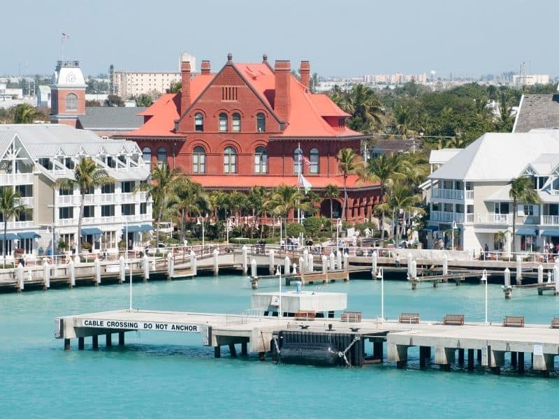 Key West downtown buildings in pink, red, and green, turquoise water of the harbor