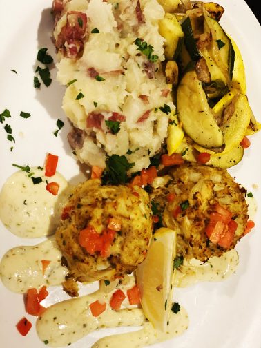 Fresh lump crab cake towers, veggies, and mashed potatoes from one of the best hook-to-table restaurants in St. Augustine,  Melbourne Beach is one of the  destinations that we love for the best romantic Florida getaways. 