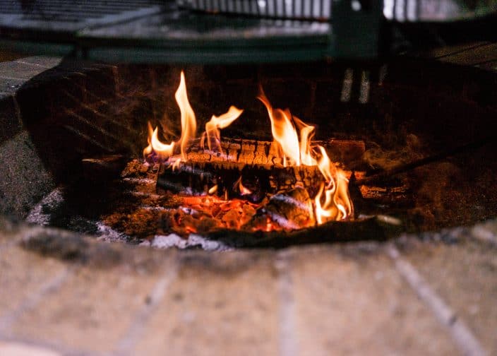 a close up shot of a fire in a brick fire pit an activity you can do to celebrate new years eve 2020