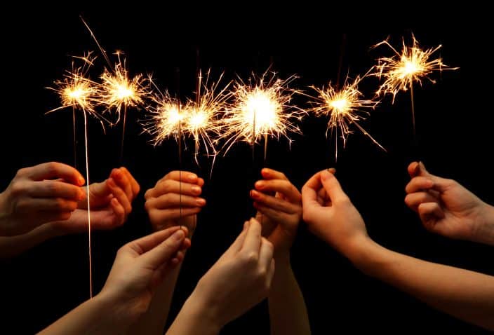 sparklers held in hands as a way to celebrate New Years Eve at home