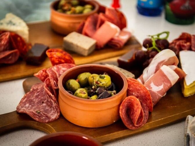 meat, cheese, and olives on a charcuterie platter