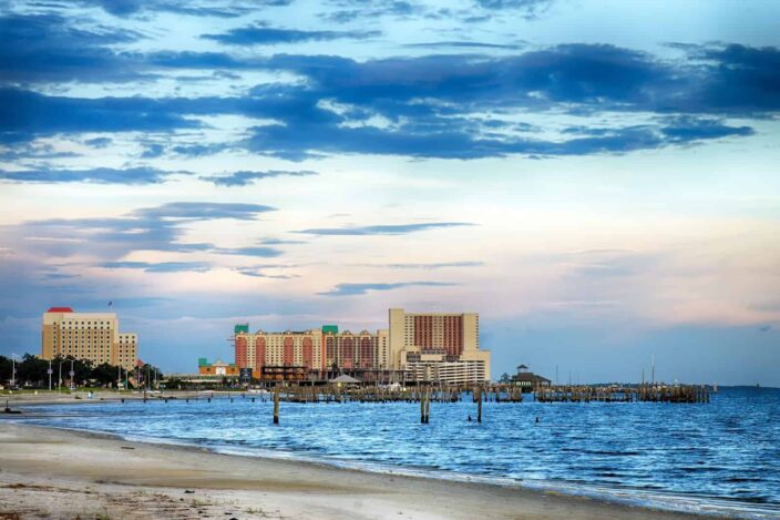 View of the shore in Biloxi, Mississippi with blue waters and casino in the background