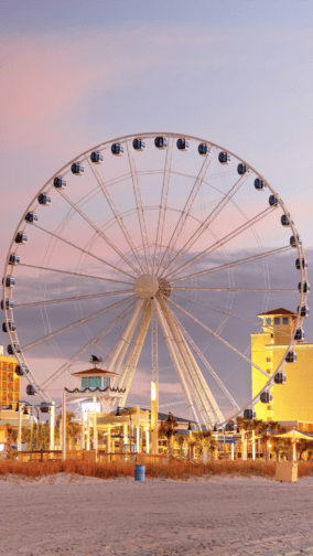 Ferriswheel on Myrtle Beach with colorful buildings in the background
