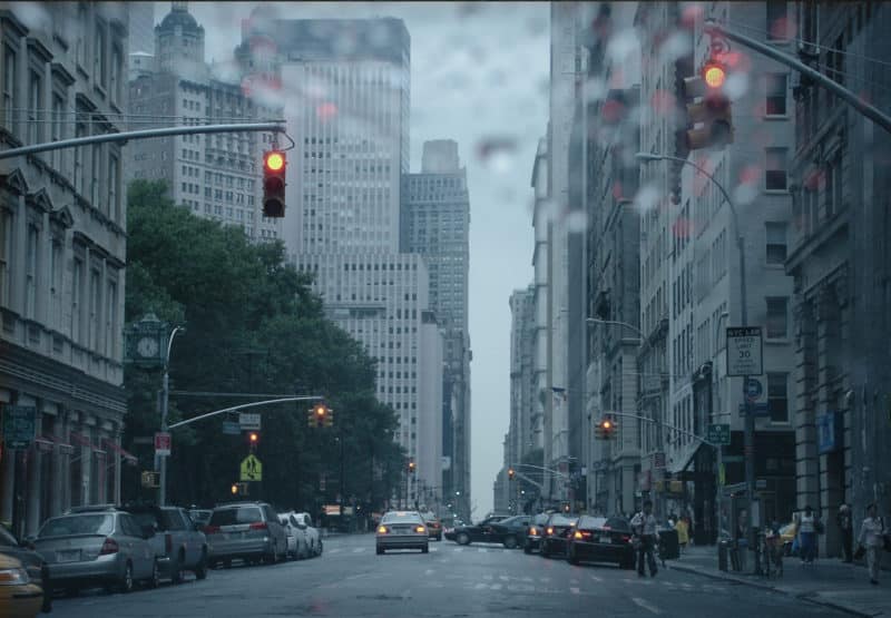 rainy day street with cars and tall buildings