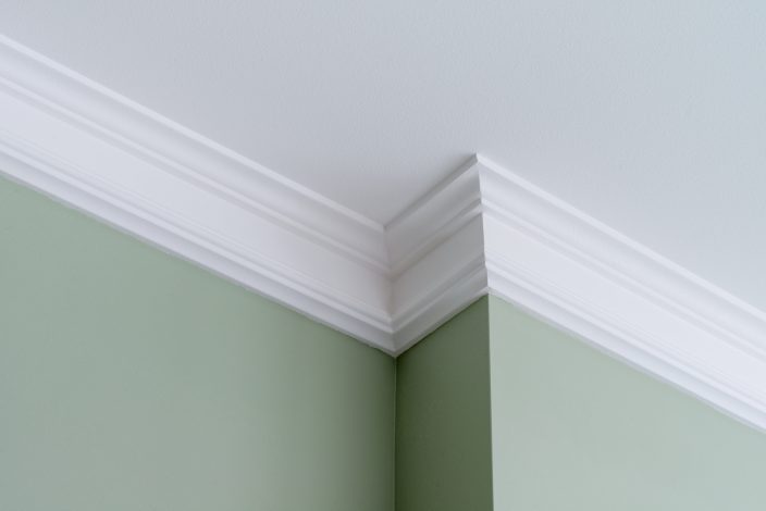 Ceiling moldings in the interior, a detail of intricate corner with green walls