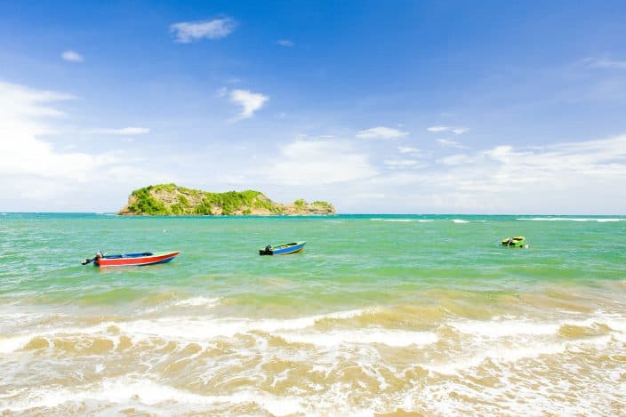 a water view of Grenada with colorful boats in the water and blue skies