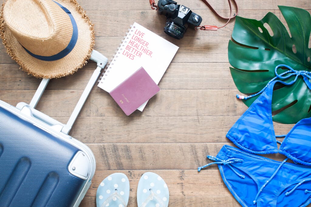 suitcase with hat, book, passport and clothing for an adults-only resorts in Florida for fun