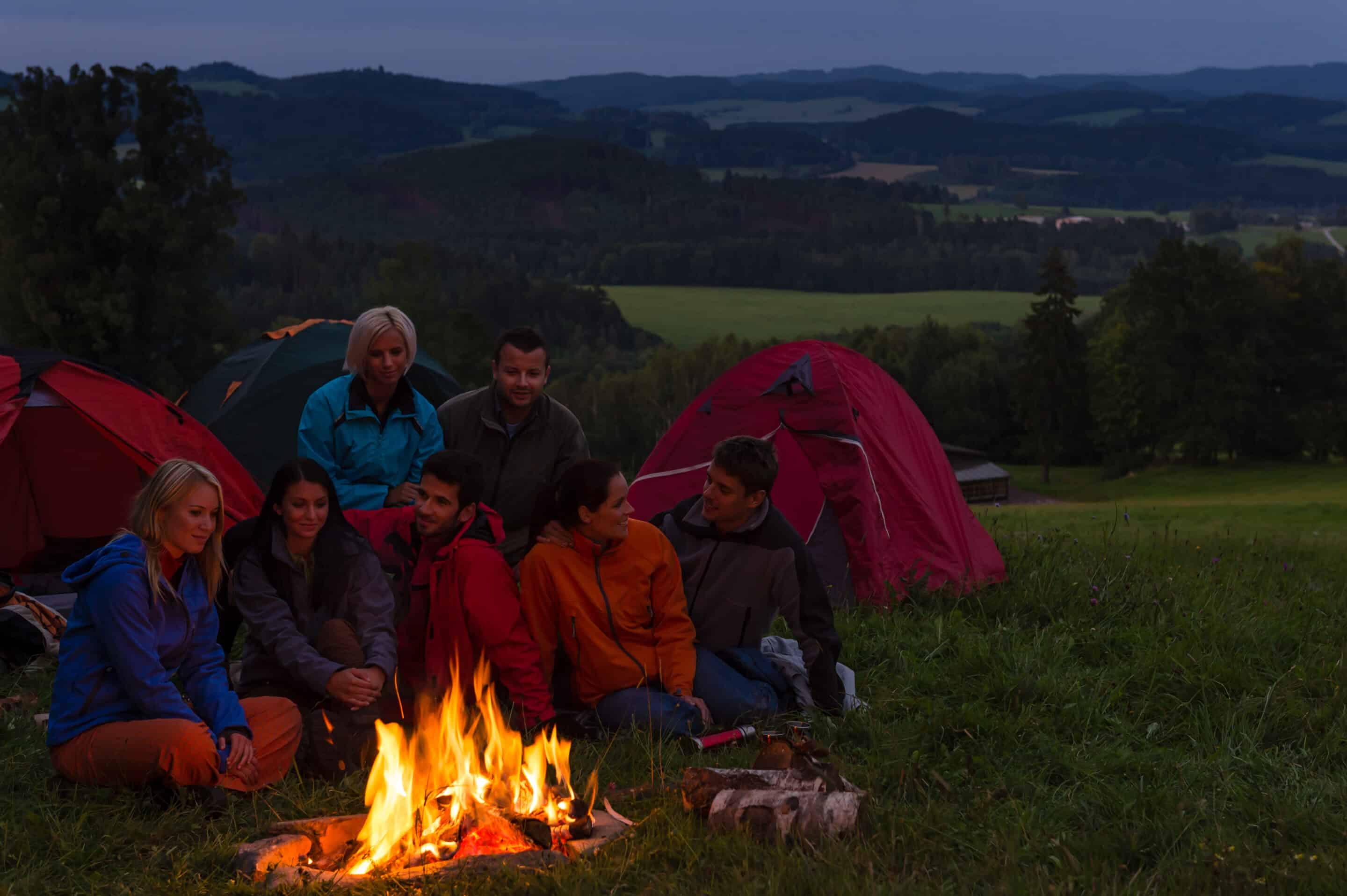 a family camping in a field at night, a fun family vacation