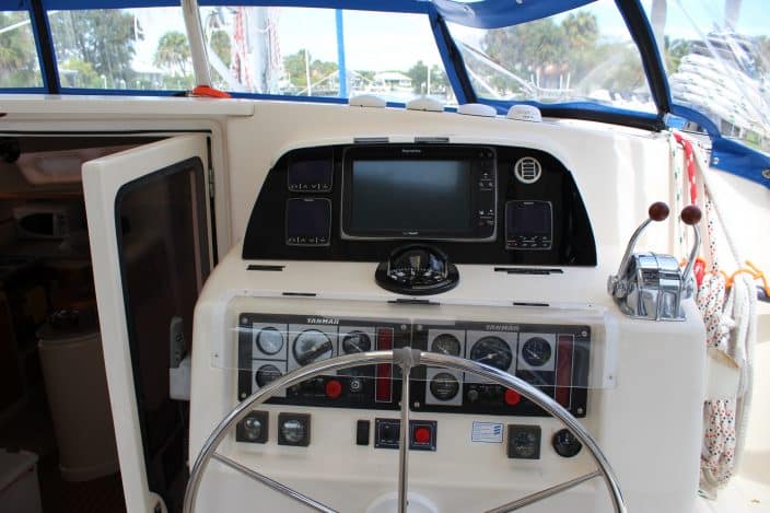 Inside view of a boat with a large silver steering wheel and buttons.Fort Pierce is a great place for boating!