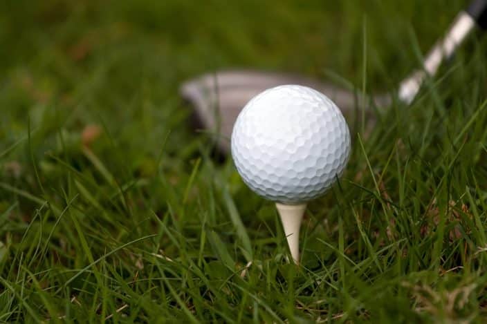 A golf ball sitting on a tee in the grass. Golf challenges await when you visit Fort Pierce
