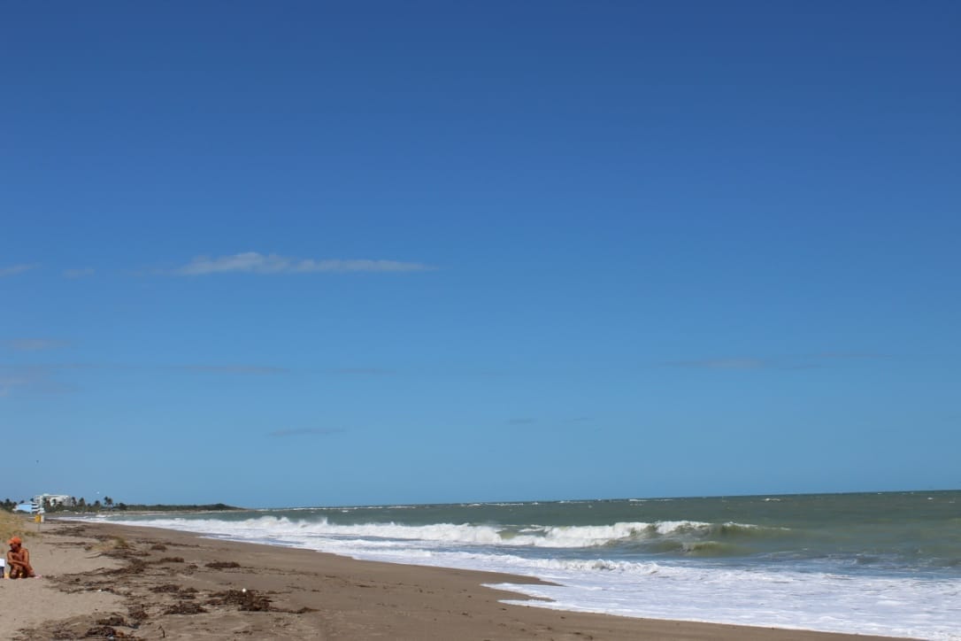 A beach with blue skies and water. Fort Pierce South Beach is a perfect place to surf