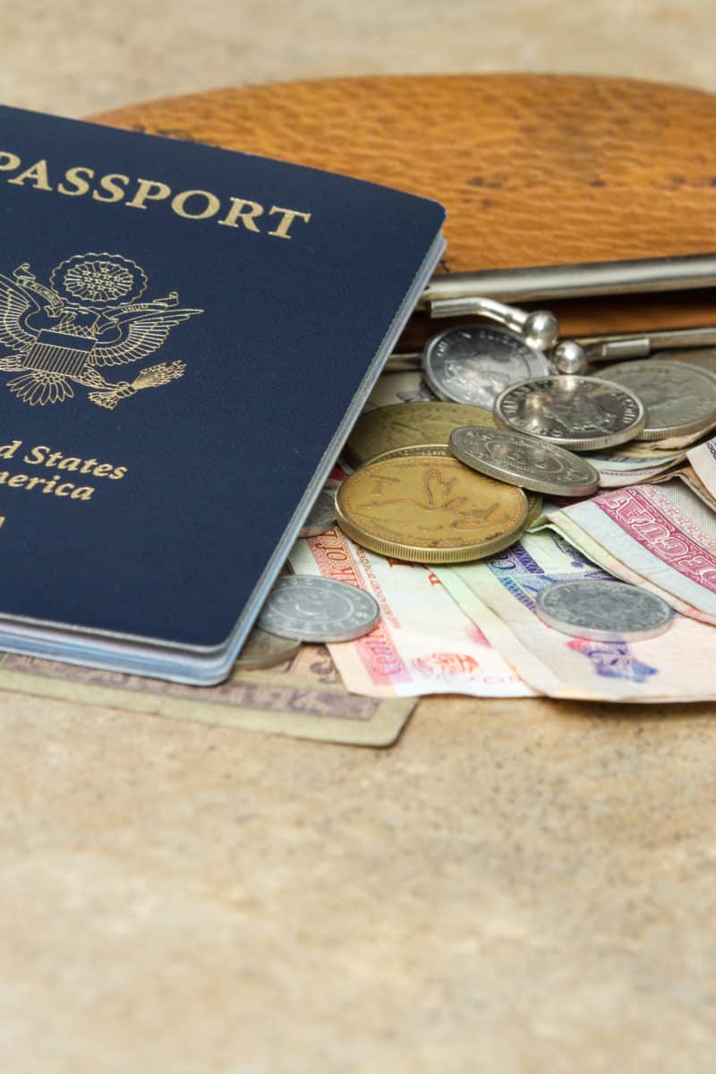 travel documents and different international currencies on a counter top