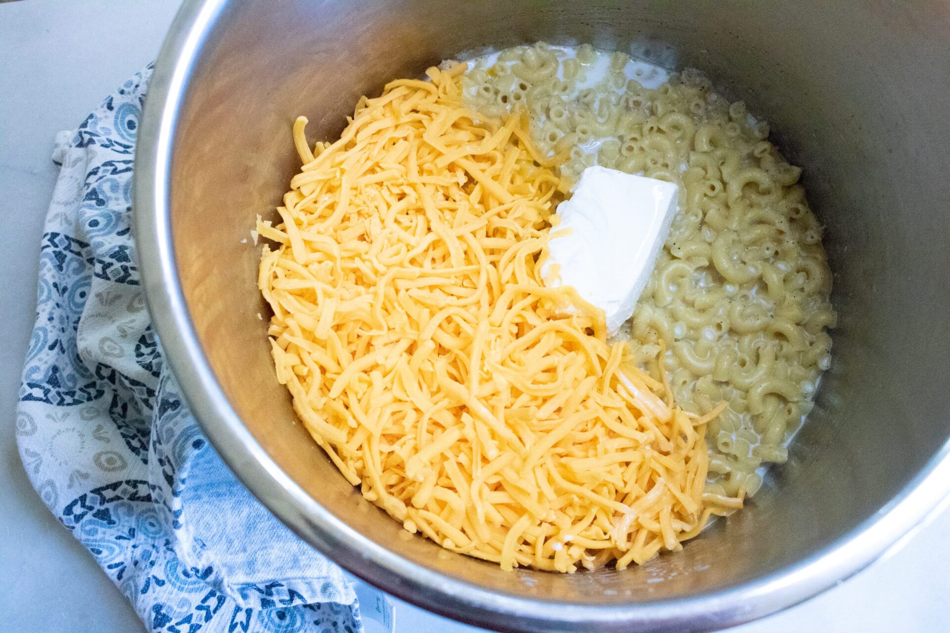add the cream cheese and cheddar cheese. Stir it all together to melt the cheese. While the cheese is melting add the milk a little at a time. When finished you should have a creamy, delicious pot of mac n cheese.