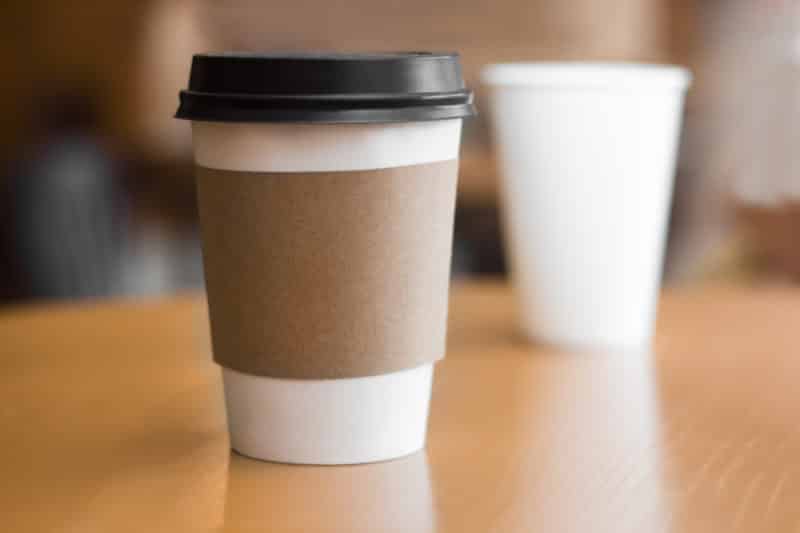 2 while paper coffee cups on wooden table