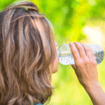 blonde haired woman drinking out of a water bottle