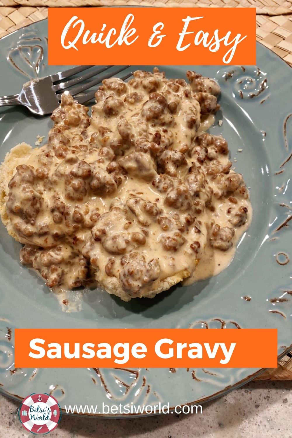 Sausage gravy on plate over biscuits with fork