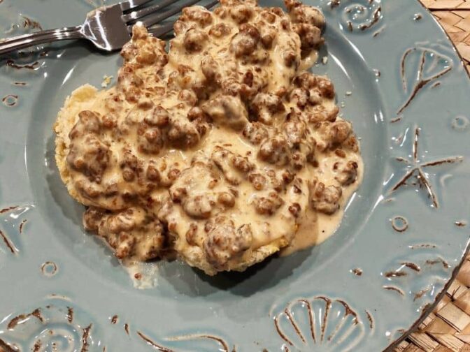 green plate with easy home biscuits smothered in sausage gravy