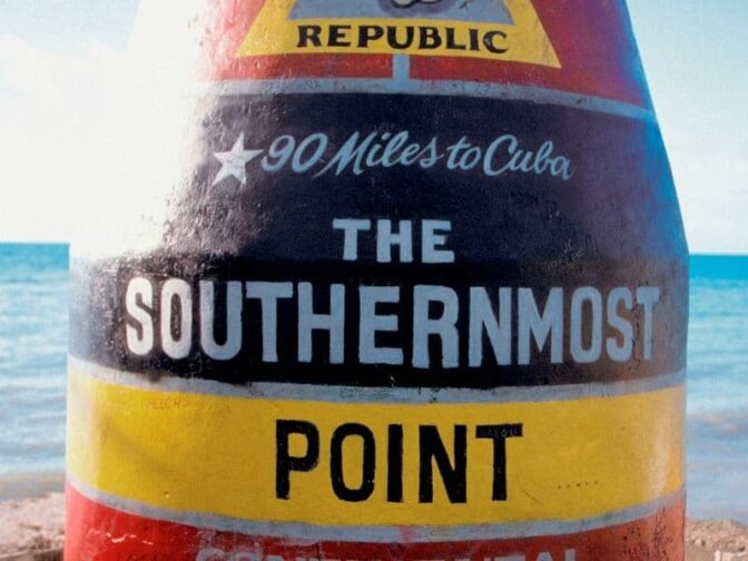 Southernmost Point Buoy marker in Key West painted yellow, black and red strips