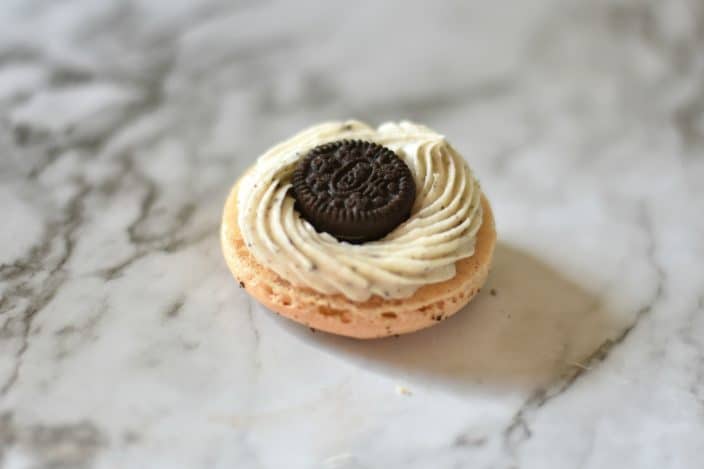 macaron cookie with a buttercream filling and a mini Oreo in the center