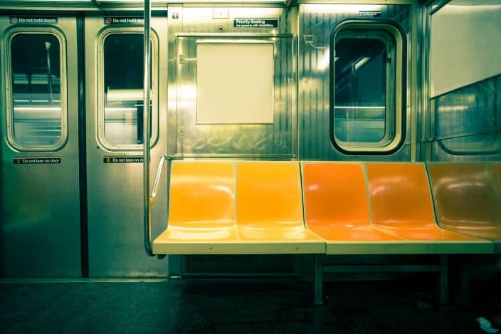 the inside of a subway car with a yellow seat, perfect for transportation for a romantic staycation