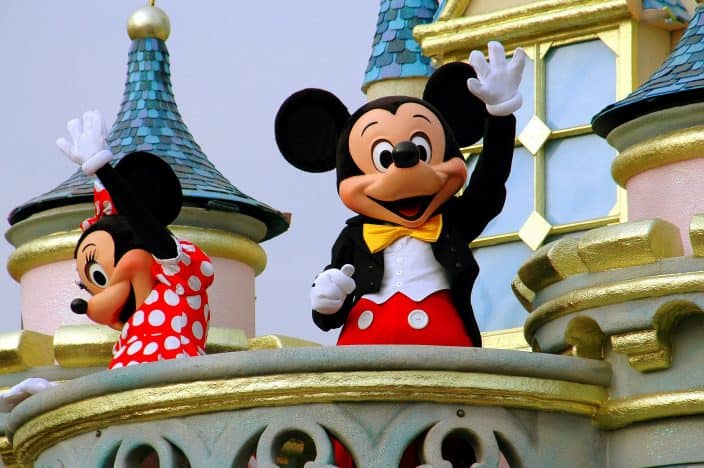 Mickey and Minnie waving at the crowd from a float at Disney World