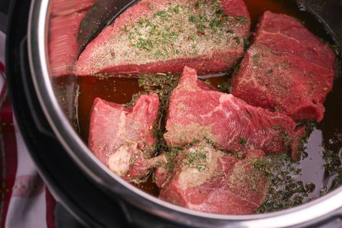 roast beef in a pot with seasoning and broth to make italian beef