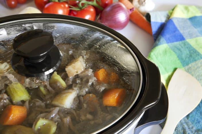 a slow cooker cooking carrots, celery, and beef