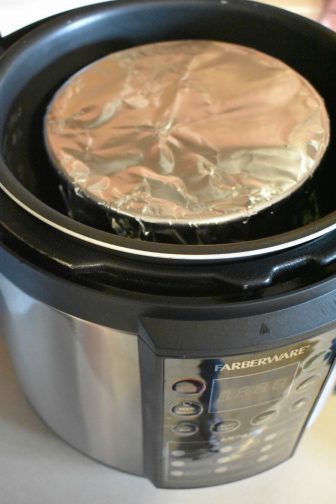 cheesecake in an instant pot with aluminum foil covering the top
