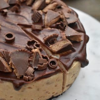 view of Reese's peanut butter cheesecake from the top with chunks of peanut butter cup on chocolate ganache frosting