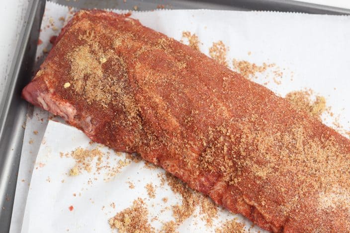 rack of ribs with a dry rub on a baking sheet