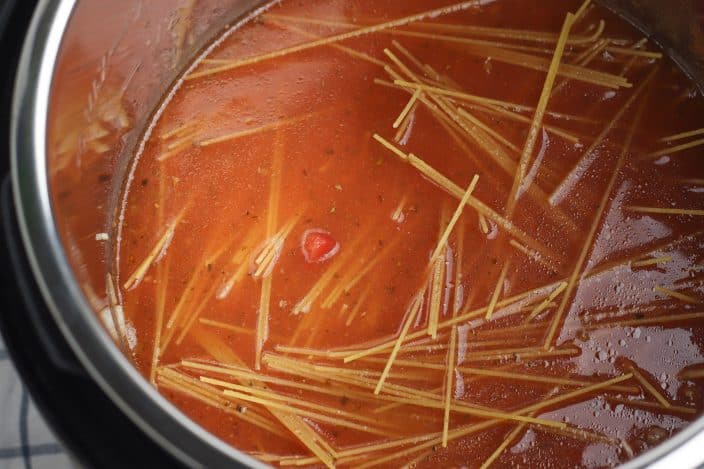 uncooked spaghetti in a meat sauce in the instant pot
