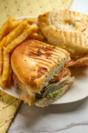 turkey pesto sandwich close up photo with french fries