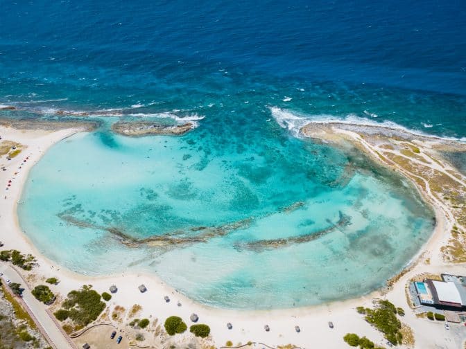 An aerial view of Baby Beach, with white sands and blue ocean, one of the best beaches in Aruba.