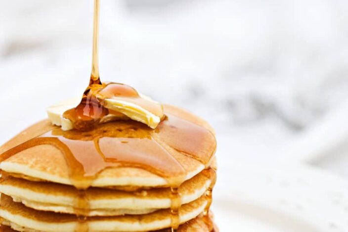 Stack of pancakes with butter and dripping with syrup an example of what you can eat in Flagler Beach