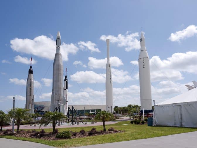 The Kennedy Space Center with model rockets on the grass