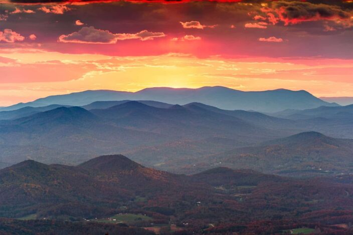 picture of the sunset with mountains and lush green trees in one frame. 