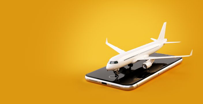 a toy airplane sitting on a smart phone on a yellow background to represent travel apps to find travel deals