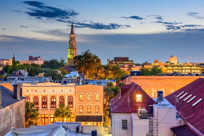 Charleston, South Carolina, skyline during sunset with pink and orange sky and multiple building tops, a South Carolina romantic getaway.