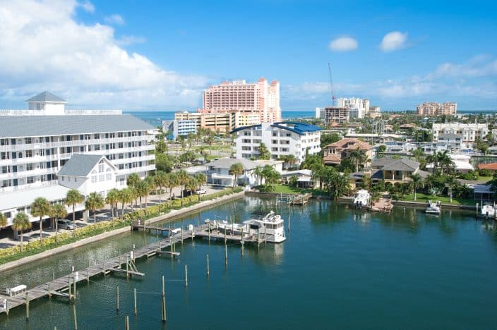 a view of a sunshine afternoon in Clearwater, overlooking the marina, with boats, condos, restaurants, and blue skies 