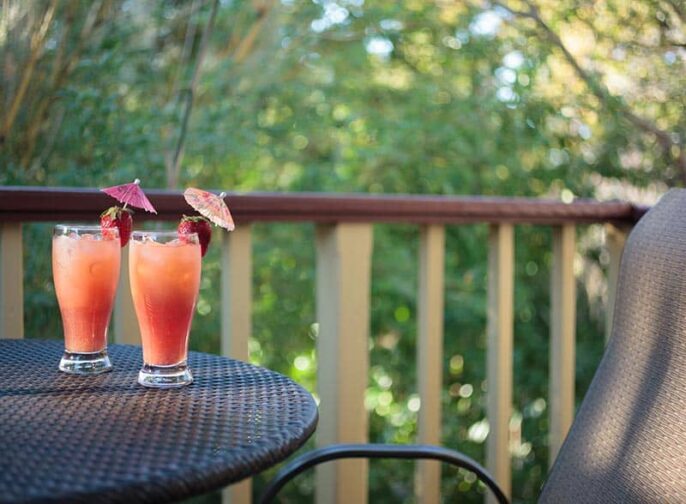 two strawberry cocktails on a patio table in the garden at the St. Francis Inn