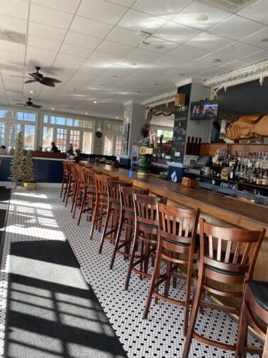 Pisces Rising restaurant with a wooden bar and black and white tile flooring in Mount Dora 