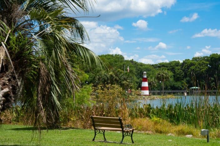 Beautiful blue partly cloudy Florida sky over Mount Dora on a summer afternoon with the Mount Dora lake and red and white lighthouse in the background