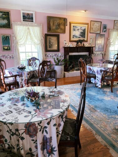 Heron Cay's Victorian Style breakfast room with pink walls and old paintings on the walls