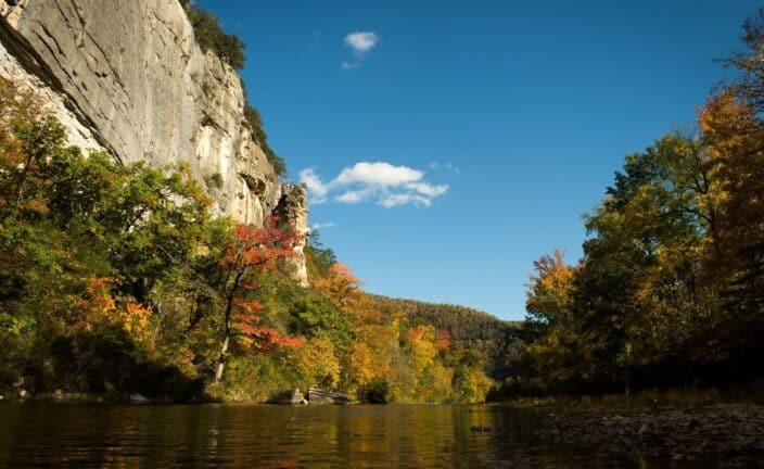 The buffalo national river with fall foliage on the trees and a rushing river, an example of what to see during your romantic getaway arkansas