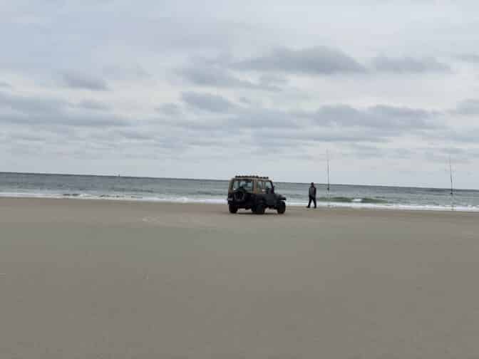 a jeep on the beach at New Smyrna Beach with grey skies and beige sands