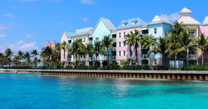a colorful resort on the coast of the Bahamas with blue skies and blue water. An example of where you could stay for a Bahamas romantic getaway