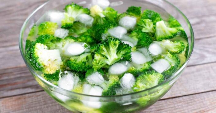 broccoli in a bowl of water with ice for the making of broccoli pasta salad
