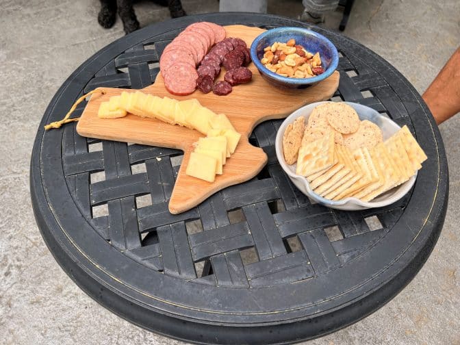  a charcuterie board with meat and cheeses on a wooden board in the shape of Texas