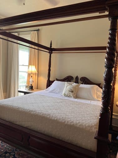 a four poster bed at the Milton Parker Home in Bryan Texas with plush linens